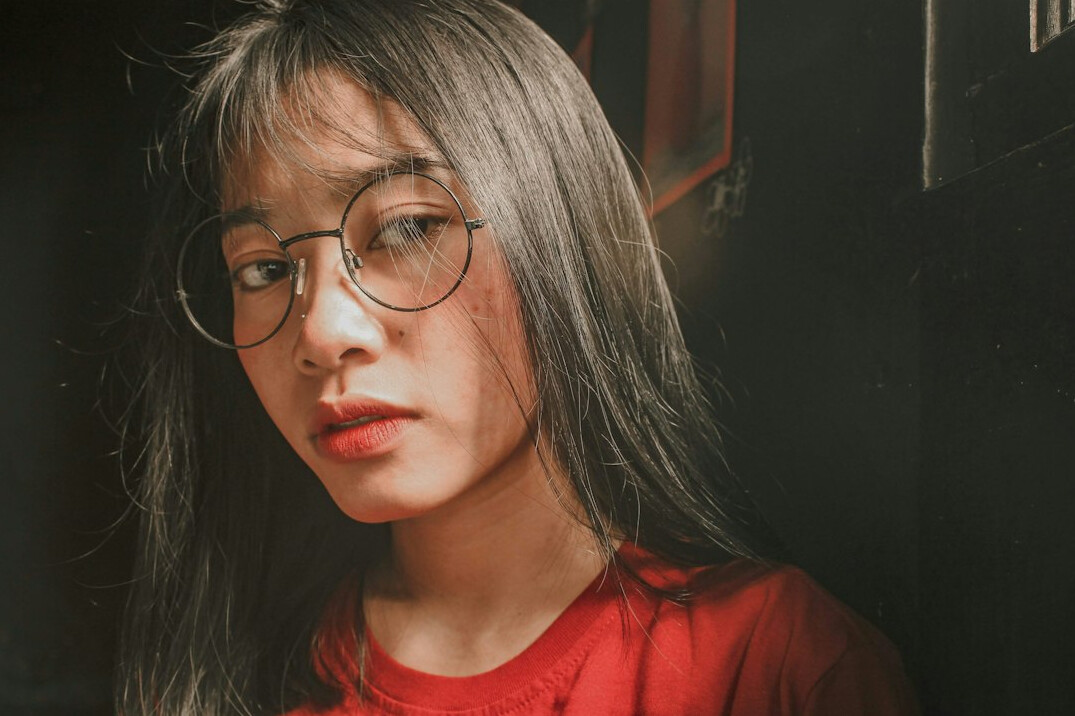 Studio portrait of a woman with grey hair and glasses
